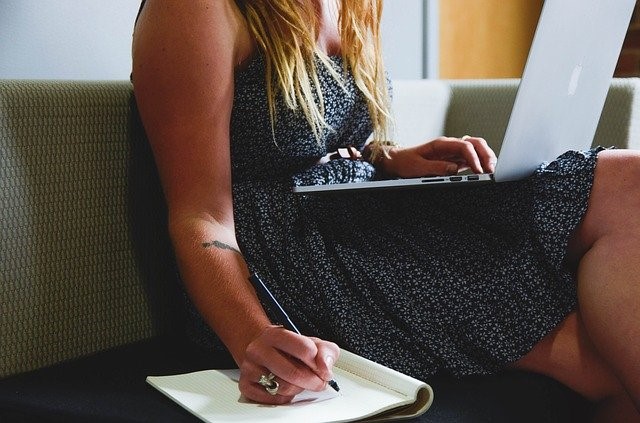 taking Note while looking at laptop